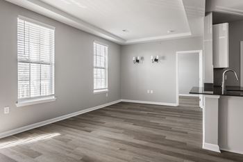 an empty living room with white walls and wood floors at Alexandria of Carmel Apartments, Carmel, IN